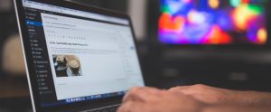 A designer working on their computer making their design portfolio website using WordPress software
