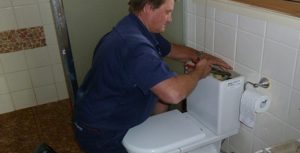 Example of a plumber fixing a commercial toilet