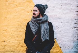 A designer posing in front of a multi-colored wall