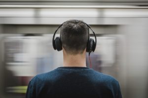 A guy listening to music while waiting for subway train