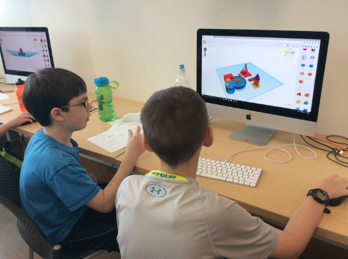 Kids sitting at the computer using Tinkercad